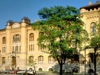Den gule fasaden til Historisk museum, og store grønne trær