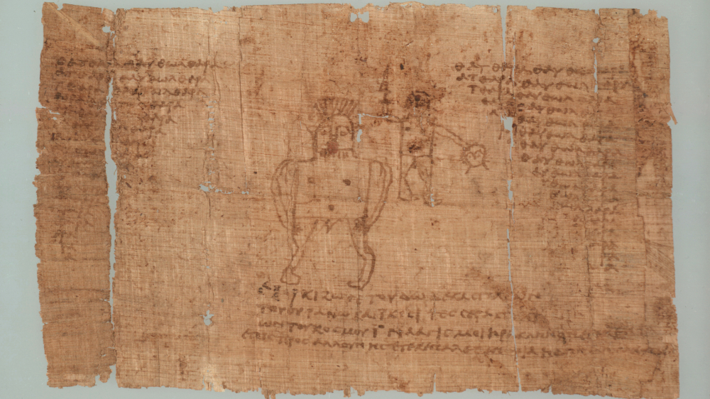 Del av papyrus, skrift og tegning på brun bakgrunn
